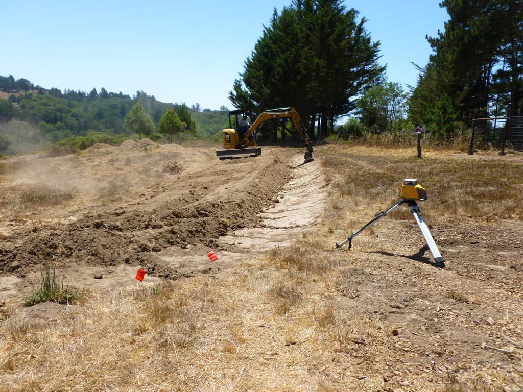 Stone and soil structures managing site drainage