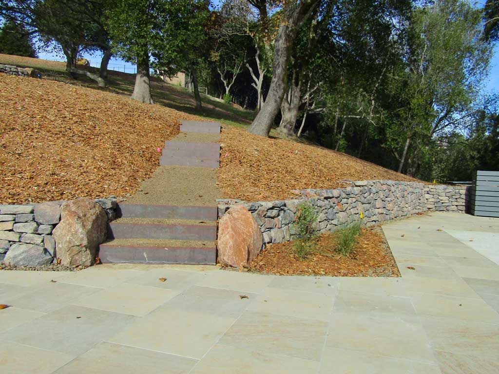 Basalt retaining wall with steel steps in a Sonoma terrace garden