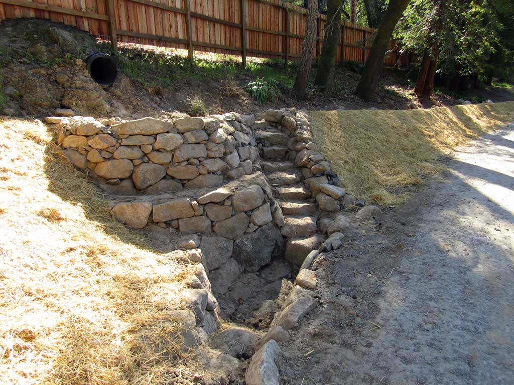Stonework diverting culvert flow into the landscape